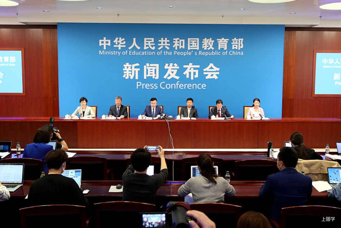 教育部新闻发布会现场，六位发言人就座，台下记者拍摄记录 · 图片来源：www.moe.gov.cn
